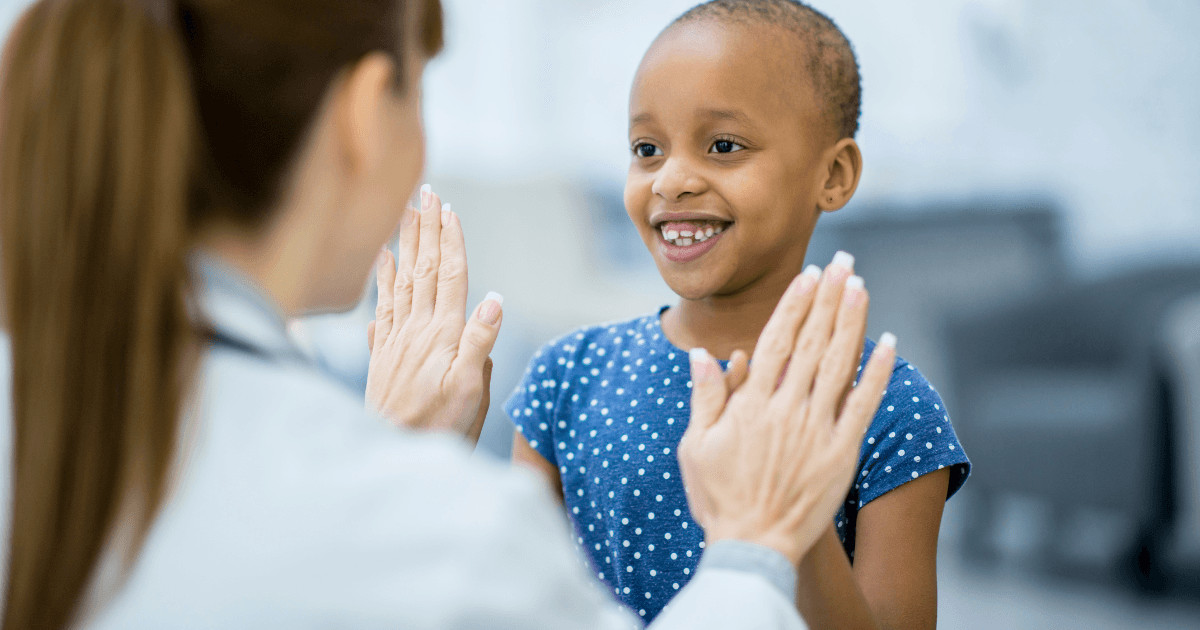 Young patient high-fiving healthcare worker, celebrating a moment of hope