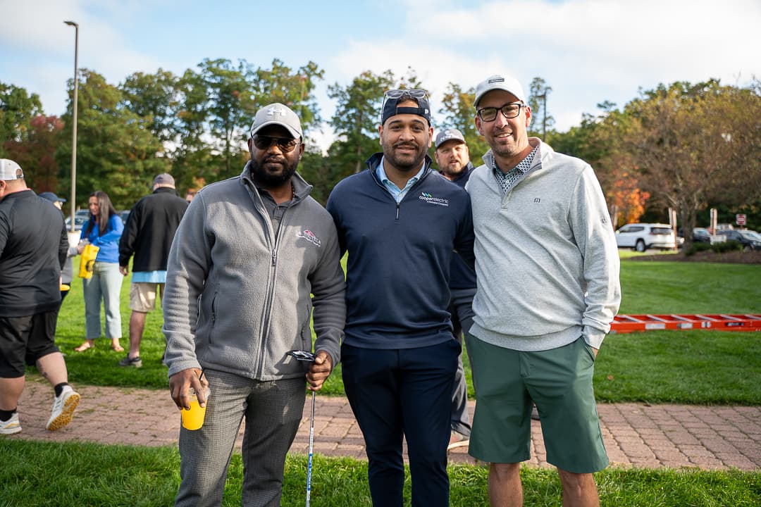 Three golfers posing together at the Live Like Brent Classic.