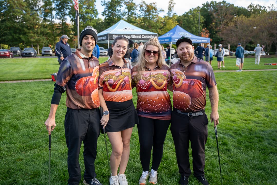 Four Classic participants posing together on the golf course.