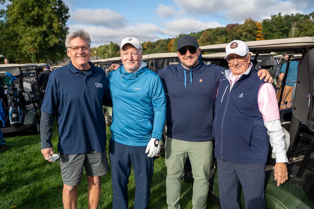 Four golfers posing with their clubs during the Live Like Brent Classic.