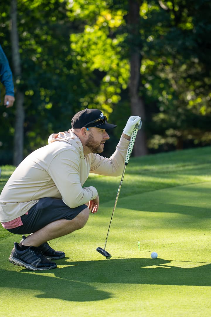 Golfer lining up a putt during the Live Like Brent Classic.