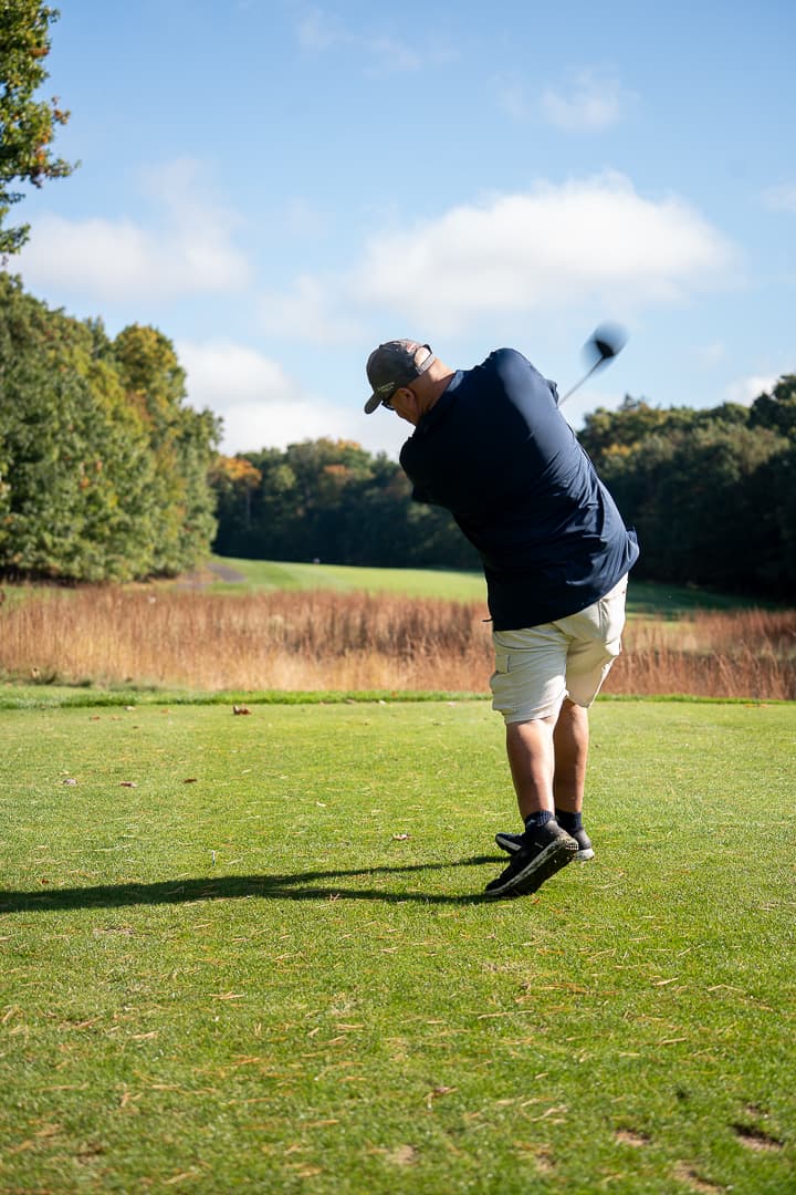 Golfer swinging on the course during the Live Like Brent Classic.